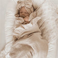 Newborn baby wrapped in a plain neutral cotton muslin blanket