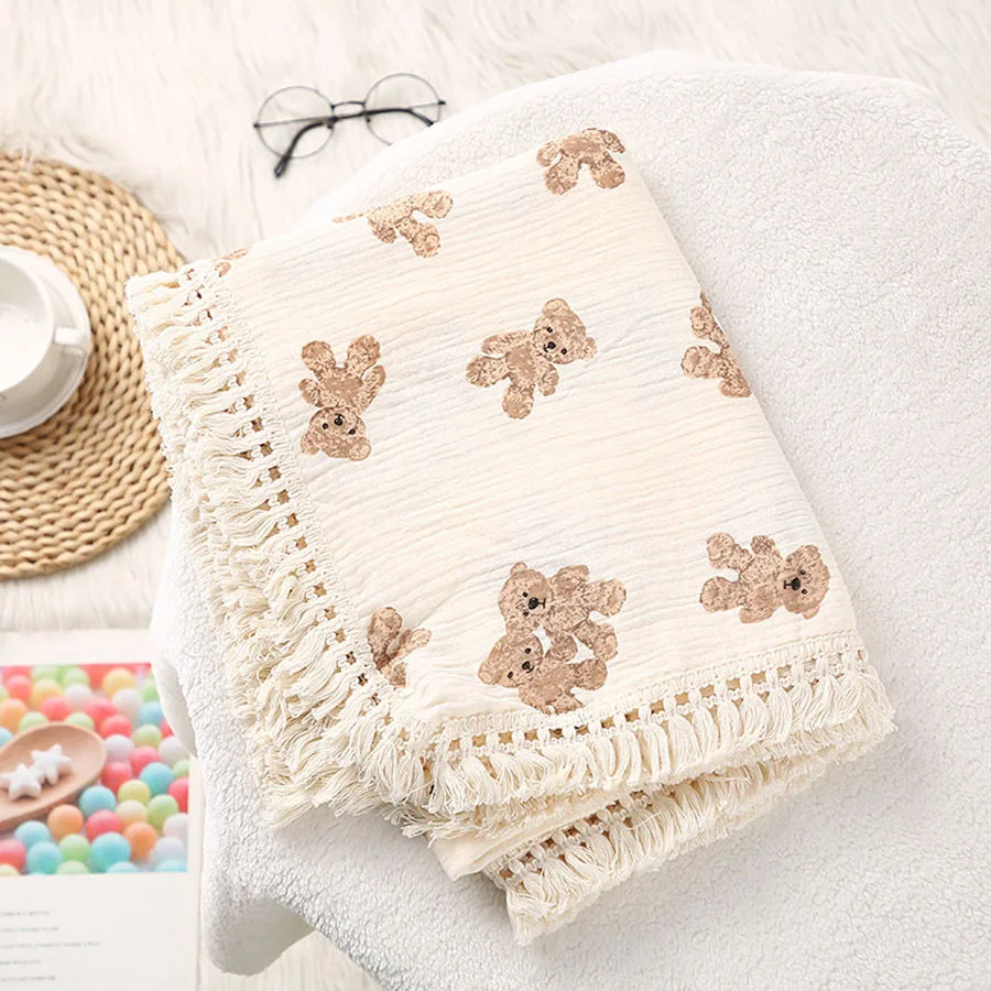 Cream cotton muslin baby blanket with bear print and knotted tassel trim