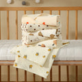 Folded layered cotton muslin baby bath towels in soft prints