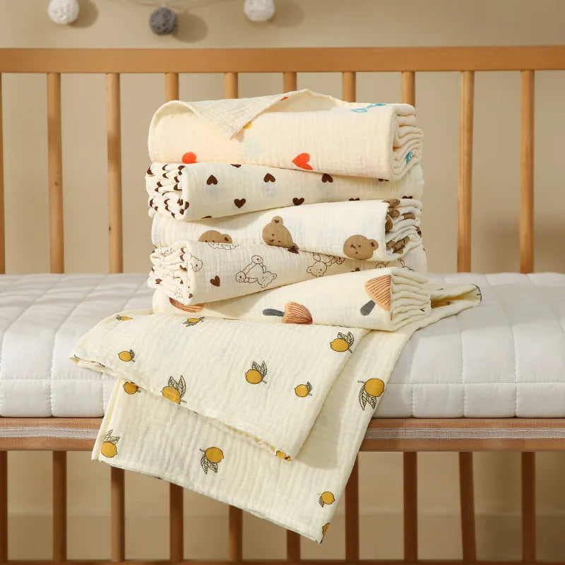 Folded layered cotton muslin baby bath towels in soft prints